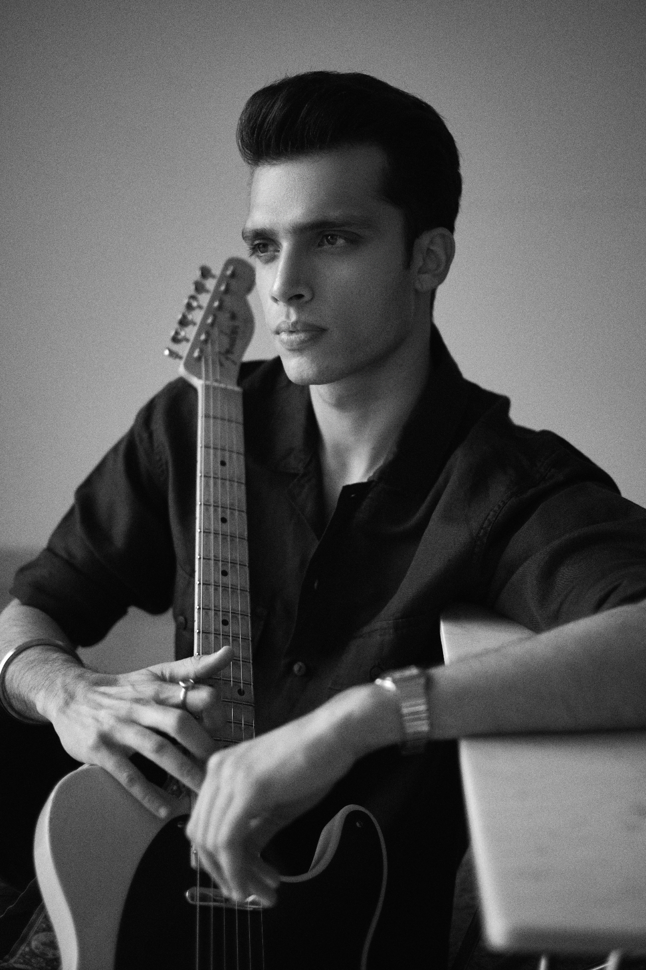 Portrait of Rish Sharma holding an electric guitar